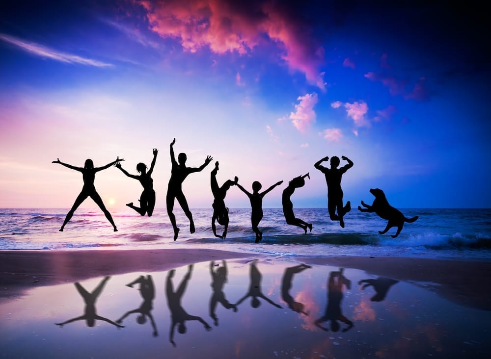 A silhouette of happy people at a beach