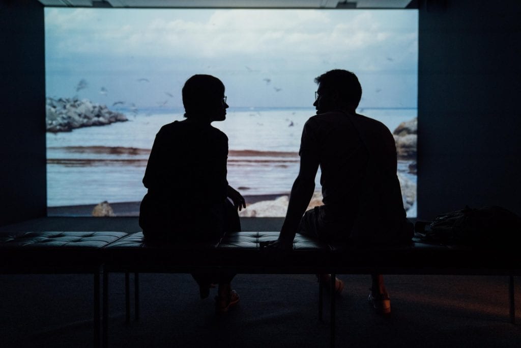 A silhouette of two people having a conversation