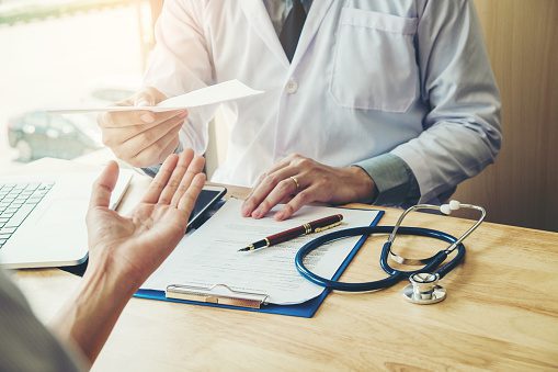 A doctor issuing a document to a patient